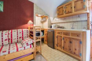 a kitchen with wooden cabinets and a counter top at Location Vanoise in Bramans