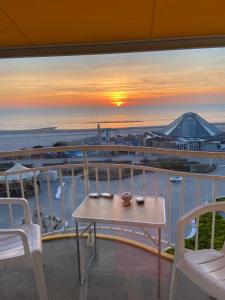 uma vista para o oceano a partir de uma varanda com uma mesa e cadeiras em Marina em Le Touquet-Paris-Plage