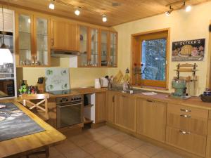 eine große Küche mit Holzschränken und einem Fenster in der Unterkunft Ferienhaus Sonne, Harz und Sterne in Hohegeiß