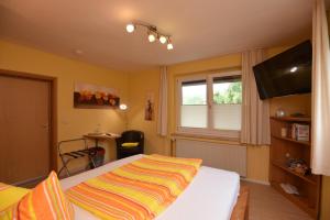 a bedroom with a bed with a colorful blanket on it at Hotel Haus Orchideental Jena in Jena +51 photos