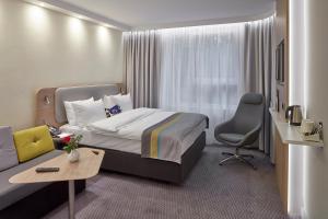 ein Hotelzimmer mit einem Bett und einem Sofa in der Unterkunft Holiday Inn Express - Merzig, an IHG Hotel in Merzig
