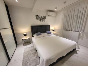 ein Schlafzimmer mit einem großen weißen Bett und zwei Lampen in der Unterkunft The View Residence in Crikvenica