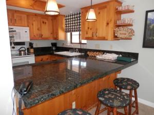 a kitchen with wooden cabinets and a counter with stools at Rr-interlaken 05 in June Lake +7 photos