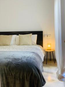 1 dormitorio con 1 cama y 1 mesa con lámpara en Puente Miraflores, en Córdoba