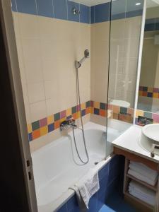 a bathroom with a shower and a tub and a sink at Appartements 4 à 5 personnes - Val d'Europe proche Disneyland in Serris