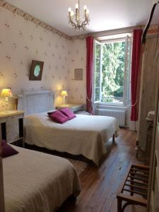 ein Hotelzimmer mit 2 Betten und einem Fenster in der Unterkunft Château de MontSablé in Lezoux