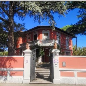 a red house with a gate and a fence at Villa Al Piano in Lastra a Signa
