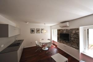 a kitchen and living room with a table and a tv at Historic center shelter in Piran +26 photos