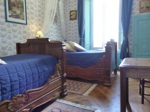 1 dormitorio con 2 camas individuales y ventana en Château de MontSablé en Lezoux