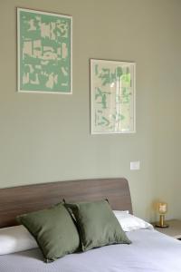 uma cama com duas almofadas e uma fotografia na parede em I Giardini Di Zelda em Policoro