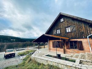 uma casa com um camião estacionado em frente em Chata nad Dziką Orlicą z jacuzzi 