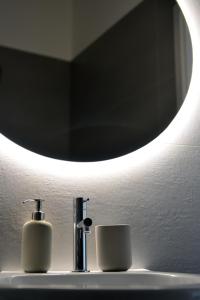 a bathroom sink with a mirror and a toothbrush at I Giardini Di Zelda in Policoro
