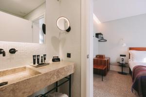 a bathroom with a sink and a bed and a mirror at 1908 Lisboa Hotel in Lisbon