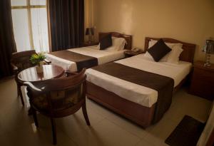 ジブチにあるComfort Hotelのベッド2台とテーブルが備わるホテルルームです。