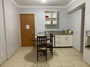 cocina con mesa, sillas y barra en Apartamento no Aguas da Serra TOP, en Rio Quente