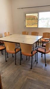 een vergaderzaal met een grote tafel en stoelen bij Warang - Nianing Chambres,Salle de séminaires et réunion in Darou Rhamane