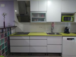 a kitchen with white cabinets and a sink at Casa Díaz in El Pont de Suert