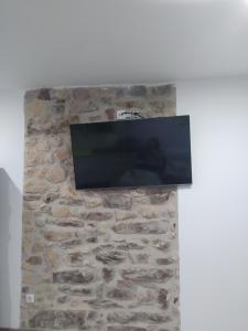 einen Flachbild-TV an einer Steinmauer in der Unterkunft Casa Díaz in El Pont de Suert