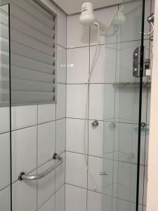 Un baño con ducha con puerta de cristal. en Apartamento no Aguas da Serra TOP, en Rio Quente