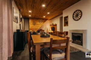 a dining room with a table and a fireplace at Refúgio na Estrela Penhas da Saúde in Penhas da Saúde