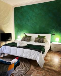 a bedroom with a large bed with a green wall at B&B mò•sì in Massa dʼAlbe