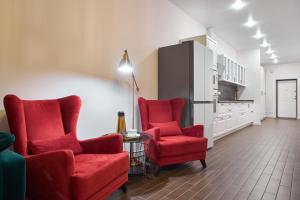 a living room with two red chairs and a table at Familiya Apartments in Gurzuf