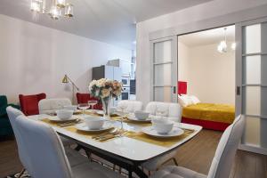 comedor con mesa y sillas blancas en Familiya Apartments, en Hurzuf