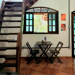 a table and chairs in a room with a staircase at Pousada e Hostel Marthi in Ubatuba