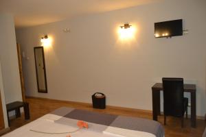 a bedroom with a bed and a desk and a television at Hotel El Tratado in Tordesillas