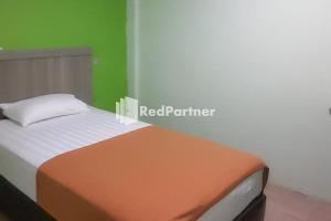 Postel nebo postele na pokoji v ubytování Guest House Anak Raja Pangkalan Bun Syariah Mitra RedDoorz