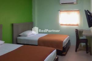 Postel nebo postele na pokoji v ubytování Guest House Anak Raja Pangkalan Bun Syariah Mitra RedDoorz