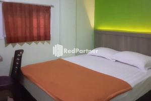 Postel nebo postele na pokoji v ubytování Guest House Anak Raja Pangkalan Bun Syariah Mitra RedDoorz