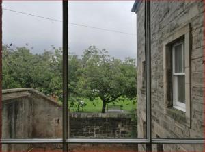 エディンバラにあるCentral Mezzanine Apartment in Historic Schoolの古い建物の窓から公園を望めます。