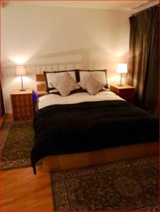 - une chambre avec un grand lit et deux lampes dans l'établissement Central Mezzanine Apartment in Historic School, à Édimbourg