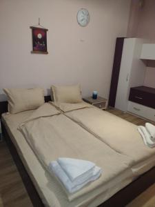 a bed in a room with a clock on the wall at Mi Casa apartment in Veliko Tŭrnovo