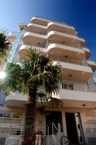 a building with a palm tree in front of it at Dolce Vita in Budva
