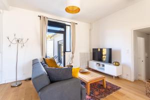 a living room with a couch and a tv at Rosalie in Saint Malo