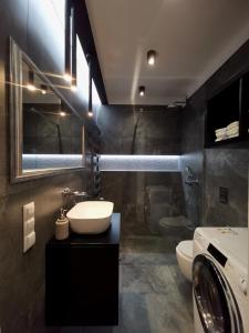 a bathroom with a sink and a washing machine at Apartament nad Odrą APARTMENT RIVER HOUSE in Szczecin