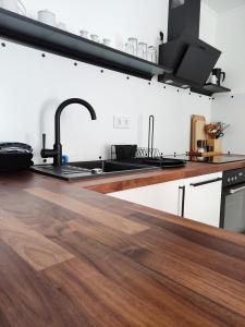 cocina con fregadero y encimera de madera en Appartement RügenZeit en Lancken-Granitz