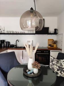 a kitchen with a table with a vase on it at Appartement RügenZeit in Lancken-Granitz