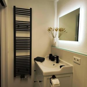 a bathroom with a sink and a mirror at Appartement RügenZeit in Lancken-Granitz