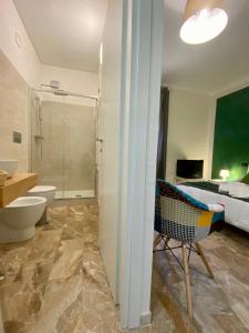 een badkamer met een douche, een toilet en een bed bij B&B mò•sì in Massa dʼAlbe