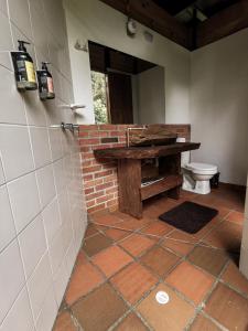 a bathroom with a table and a toilet in a room at Glamping El Color de mis Reves Recinto del Pensamiento in Manizales