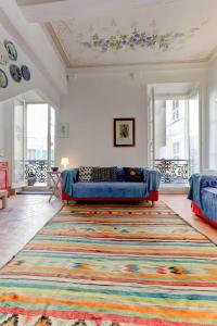 un soggiorno con divano e un grande tappeto di Les Fresques a Mentone