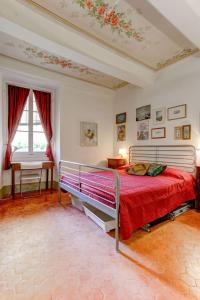 una camera da letto con un grande letto con una coperta rossa di Les Fresques a Mentone