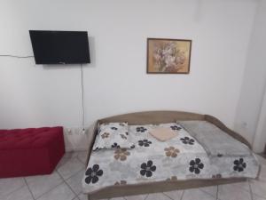 a bedroom with a bed and a red couch at Kitinete Antonio X in Campos dos Goytacazes