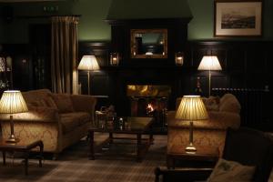 a living room with two couches and a fireplace at Bunchrew House Hotel in Inverness
