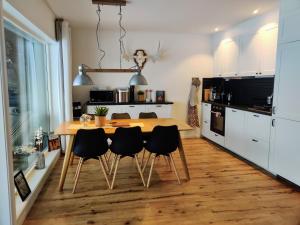 a kitchen with a wooden table and black chairs at Book in Borgafjäll - New cabins for rent at the slalom slope in Borgafjäll