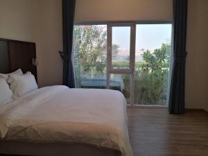 a bedroom with a bed and a large window at Almorouj Farm inn - Bidiya in Bidiyah +31 photos