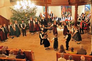 a group of people dancing in front of a christmas tree at Gîtes et chambres d'hôtes Maison Ungerer in Hunspach